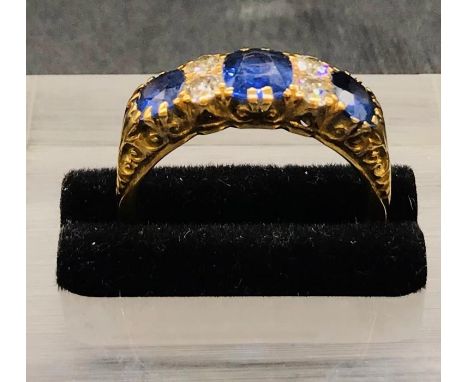 An 18 ct yellow gold three stone Sapphire and Diamond Ring