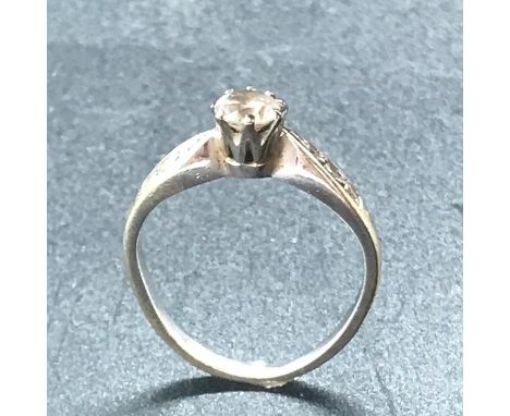 An 18ct white gold ring with central diamond and three stone diamond shoulders.