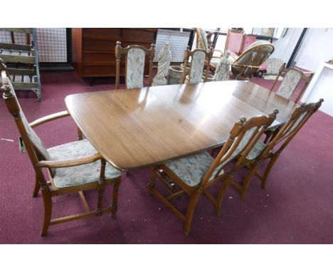 An Ercol dining table with two extra leaves, H.74 W.250 D.101cm, together with 6 matching dining chairs to include two carver