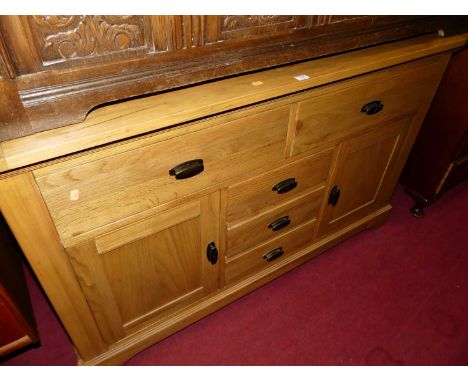 A contemporary light oak sideboard, fitted with five short drawers and twin cupboard doors, w.142cm