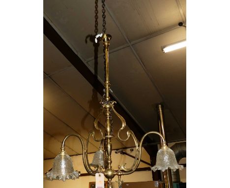 An Art Nouveau turned brass hanging three-branch ceiling light, having shaped frosted glass shades, of ornate floral form, dr