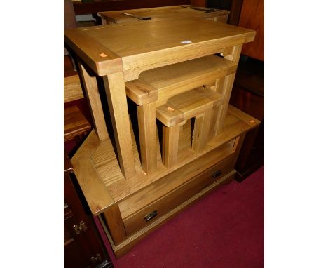A contemporary light oak nest of three occasional tables, the largest w.65cm; together with a matching media unit with single