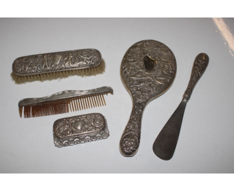 A silver back dressing table hand mirror, brush, comb, shoe horn, and tidy jar