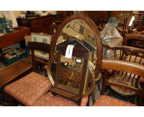 An Edwardian mahogany mirror with shelf; an oak framed oval bevel edged wall mirror and two gilt framed mirrors 