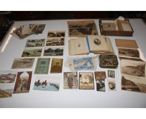 A box of vintage black and white photographs and a wind chime  