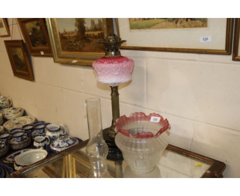 A 19th century brass column oil lamp with opaque glass reservoir and tinted shade