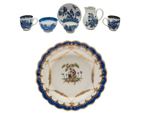 A First Period Worcester dessert plate and six pieces of blue and white porcelain: the plate painted with a 'fancy bird' in a
