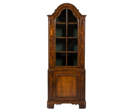 A walnut veneer domed upright display cabinet in the Queen Anne taste:, with a moulded cornice and green painted interior wit