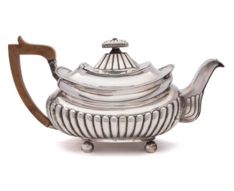 A George III silver teapot, Michael Starkey, London, 1809: crested, of barge shaped outline having half reeded decoration, ra