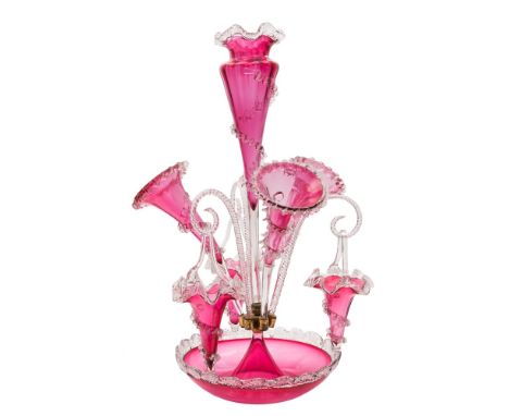 A cranberry glass table epergne: with central vase set in a circular bowl and flanked by three curved trumpets all with toole