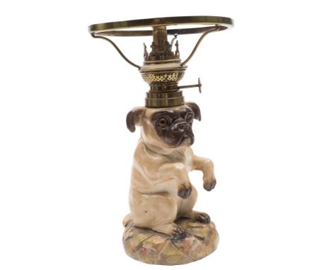 A Continental porcelain table lamp in the form of a begging pug: modelled on it's hind quarters with raised paws on a mound b