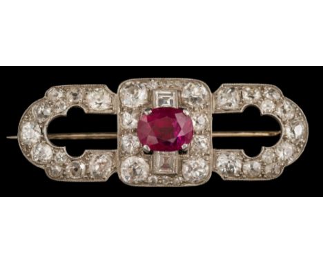 A white metal, ruby and diamond oblong brooch: with central single, oval ruby between step-cut diamonds and within a surround