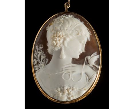 A carved oval shell cameo portrait pendant/brooch: depicting a young woman with pearl necklace and a bird, within a rope-twis