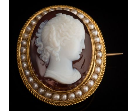A Victorian layered agate cameo portrait brooch: the white agate cameo carved depicting a young woman in profile, 30mm x 23mm