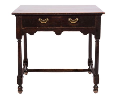 An 18th century oak and fruitwood rectangular side table: with an overhanging top, fitted with a drawer in the shaped apron o