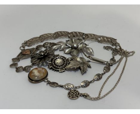 Two filigree white metal bracelets, three floral white metal brooches, silver stiff bangle, a Celtic style panel bracelet and