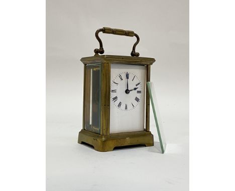 A Late 19th century brass carriage time piece clock, the case with swing handle above a bevelled view glass and all round gla