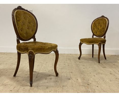 A pair of Victorian rosewood framed drawing room chairs, with floral carved crest rail above a button upholstered seat and ba