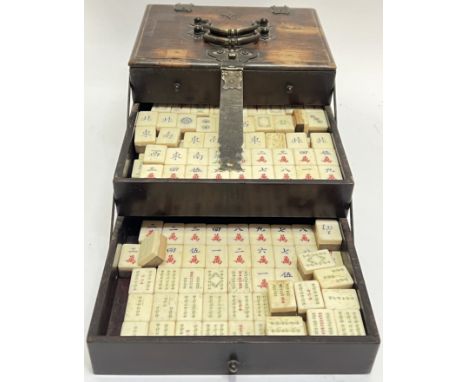 A late nineteenth/early twentieth century Chinese Mahjong travel set comprising a quantity of bone/wood counters in a three t
