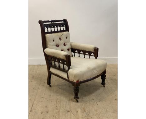 A large Victorian mahogany famed armchair in the style of Christopher Dresser, circa 1870, the turned crest rail above an arc