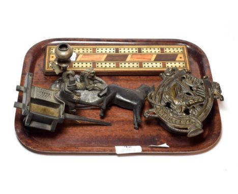 A primitive carved wood horse and cart, a cast iron money box, a cribbage board, a candlestick with mythological horse