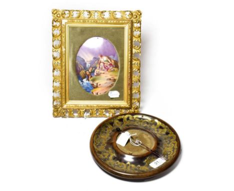 A Victorian circular brass inkstand dish, with pen and a Continental porcelain plaque depicting three figures, mounted in a c