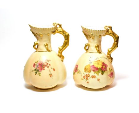A pair of Royal Worcester blush ivory ewers, 16.25cm. .  Some patches of wear to the gilding. No chips, cracks or repair. 