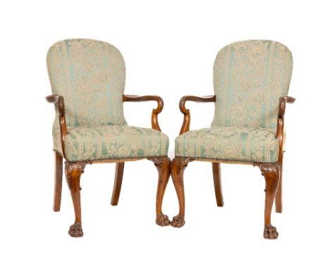 A good pair of Chippendale style mahogany Library Armchairs, each with oval arched and padded back with two out-curved carved