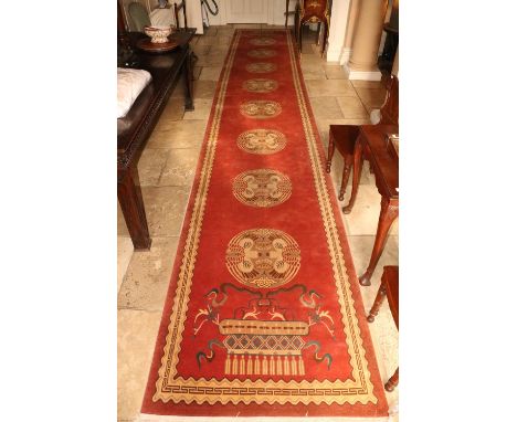 A fine Nepalese deep pile woollen Runner, the iron red ground with a row of eight roundels, inside a slim cream border, appro