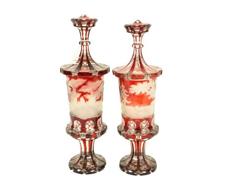 An extremely fine pair of Bohemian ruby Urns and Covers, c. 1870, each etched with a woodland scene, with deer on a stem base