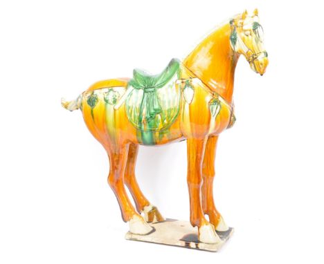 A large 20th century Chinese reproduction Tang dynasty style ceramic war horse figurine. Orange, straw and green&nbsp;glazes.