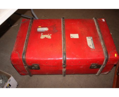 A red painted and wooden bound travelling trunk 