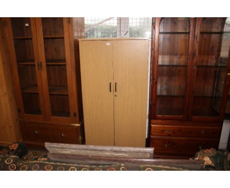 A light oak veneered cupboard 