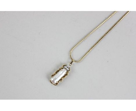 A baroque pearl and diamond pendant in 14ct yellow gold on an 18ct gold neck chain