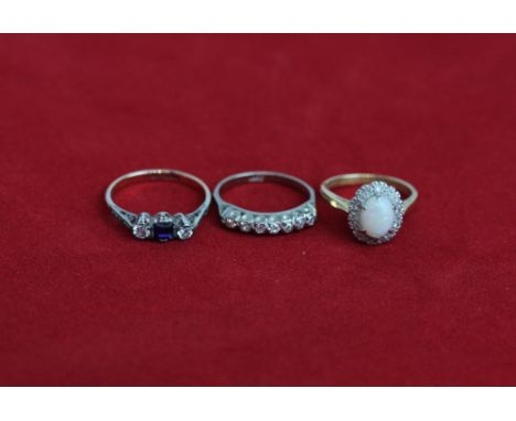 A diamond seven stone half hoop ring, and opal and diamond cluster ring, a blue and white three stone ring