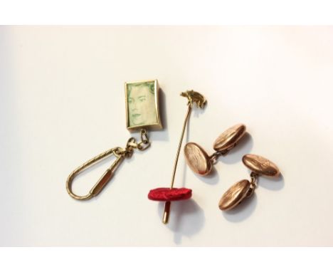 A pair of 9ct gold oval cuff links 5.6g; a gold novelty stick pin; a 9ct gold cased £1 note key ring