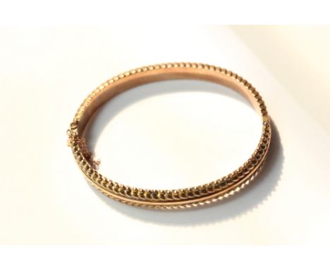 A 9ct gold hinged bangle with beaded border 10g