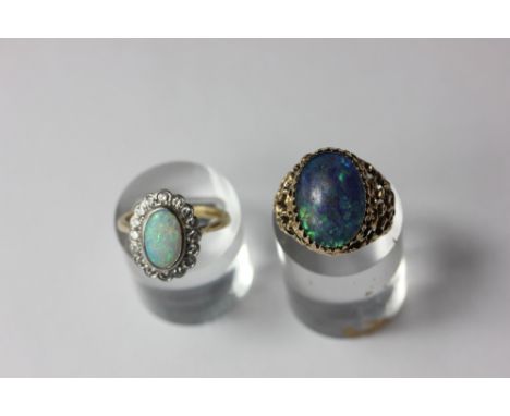 An opal and diamond ring the oval cabochon within a diamond border; an opal doublet dress ring the oval stone multi claw set 