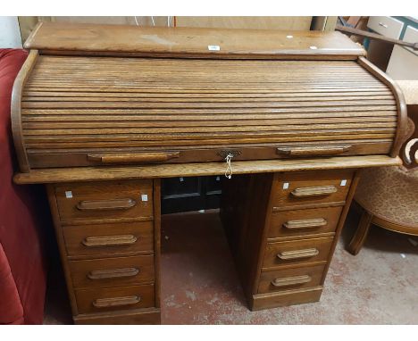 A 1.2m vintage oak roll-top desk with part-fitted interior and eight flanking pedestal drawers