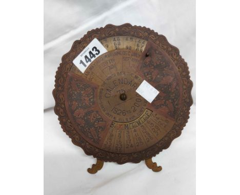 A 1920's brass 75 year calendar of easel form, covering dates from 1926-2000, with swivel disc to front and chased decoration