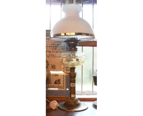 A Victorian oil lamp with cut glass reservoir, set on a brass column base, with chimney and opaque glass shade