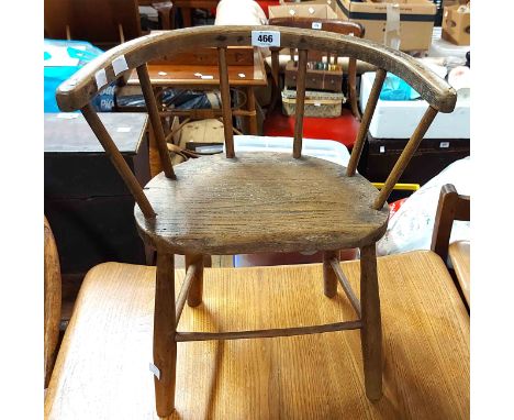 A vintage mixed wood child's stick back bow elbow chair with solid elm seat, set on turned supports