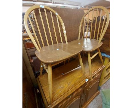 A set of four 1980's Ercol light elm hoop stick back kitchen chairs with moulded solid seats, set on simple turned supports