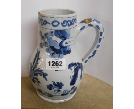 An 18th Century Delftware jug of tankard form with hand painted blue chinoiserie decoration, depicting figures in a landscape