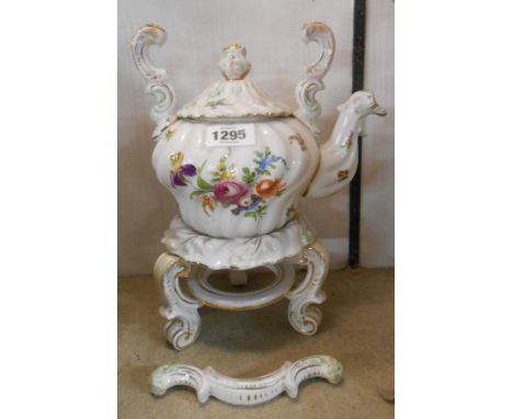 A German porcelain spirit kettle and stand in the Dresden style decorated with Rococo scrolling and hand painted floral spray