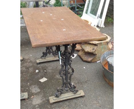 A vintage tavern table with wooden top, set on a cast iron base