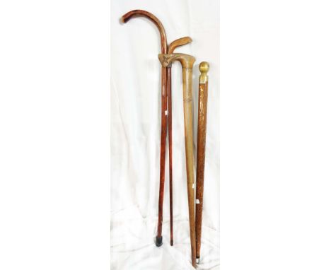Two novelty walking sticks, one of golf club form with silver collar, the other of tribal axe form - sold with another and a 