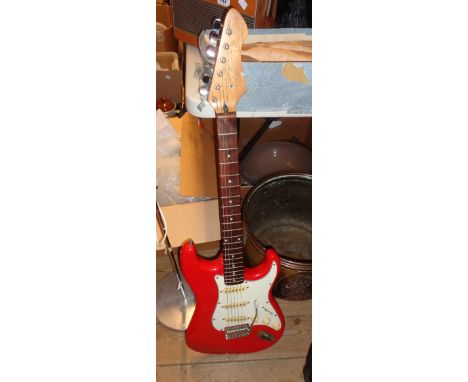 A vintage Fender Stratocaster copy, with red finish, in soft carry case