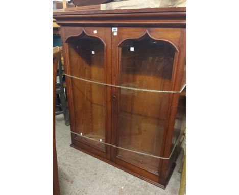 A 1.04m Victorian stained wood book cabinet with adjustable shelves enclosed by a pair of glazed panel doors, set on an assoc