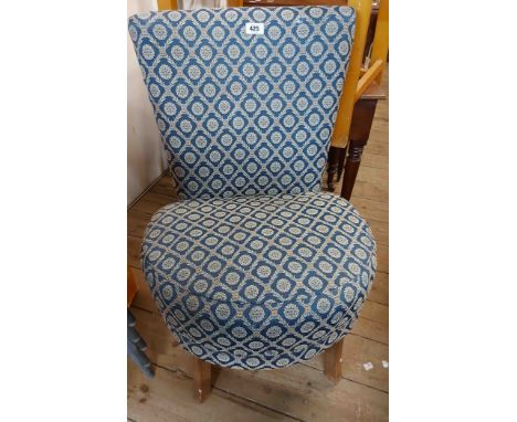 A vintage boudoir chair with repeat pattern tapestry upholstery and circular seat, set on swept legs